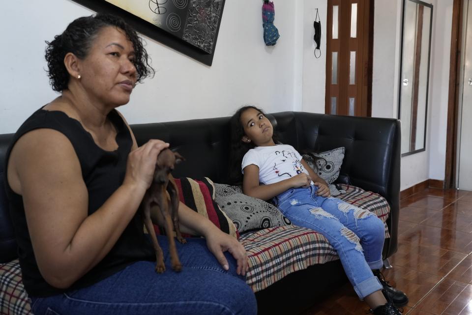 Valerie Torres listens as her mother Francys Brito speaks during an interview in their home in Caracas, Venezuela, Sunday, Feb. 26, 2023. Brito said she has tried to shield her 9-year-old daughter from the worst of Venezuela’s protracted crisis. (AP Photo/Ariana Cubillos)