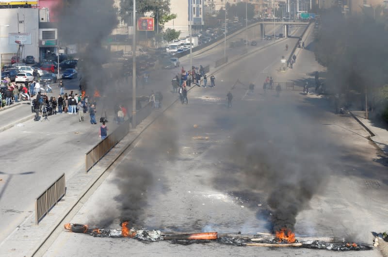 Protestors close a road with burning barricades during a protest over economic hardship and lack of new government in Beirut