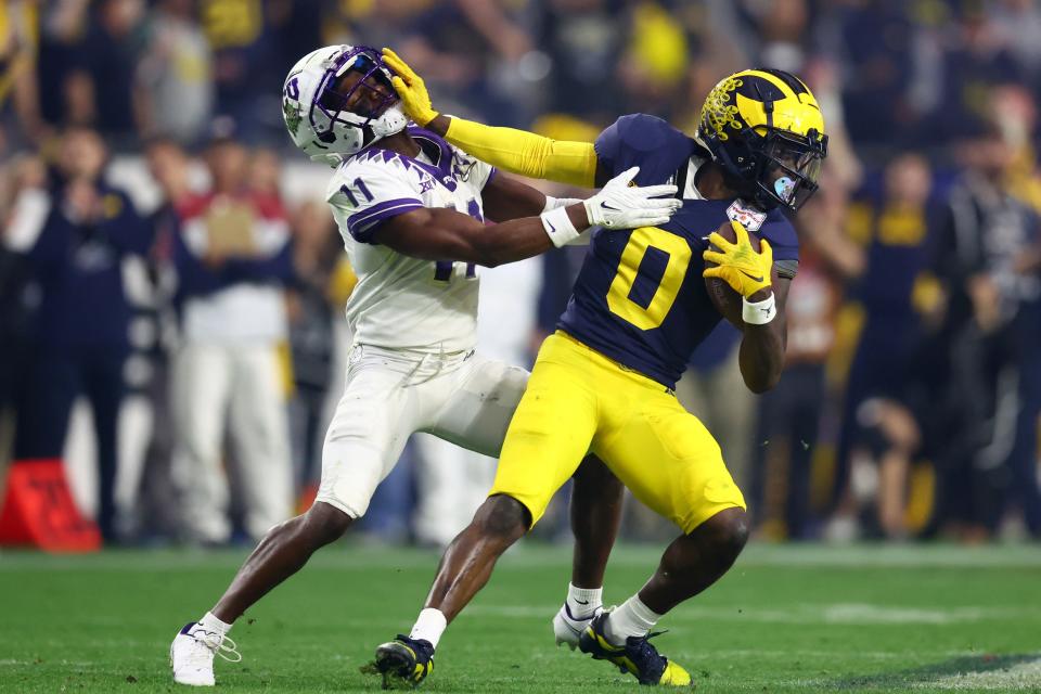 Dec 31, 2022; Glendale, Arizona, USA; Michigan Wolverines defensive back Mike Sainristil (0) stiff arms TCU Horned Frogs wide receiver Derius Davis (11) in the third quarter of the 2022 Fiesta Bowl at State Farm Stadium. Mandatory Credit: Mark J. Rebilas-USA TODAY Sports