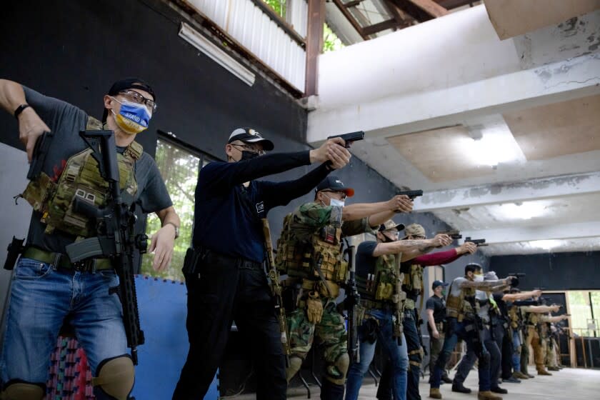 People shoot at targets with air pistols during a shooting training session at Taiwan CBQ Club in New Taipei City