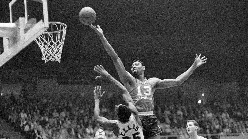 Wilt Chamberlain during his playing days with the Philadelphia 76ers, here against the LA Lakers, with Jerry West (right) looking on. - Bettmann Archive/Getty Images