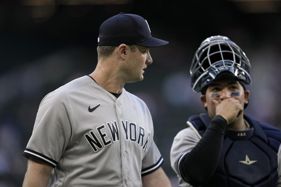New York Yankees starting pitcher Gerrit Cole, left, talks with catcher Jose Trevino as they arrive at the dugout for the team's baseball game against the Texas Rangers, Thursday, April 27, 2023, in Arlington, Texas. (AP Photo/Tony Gutierrez)
