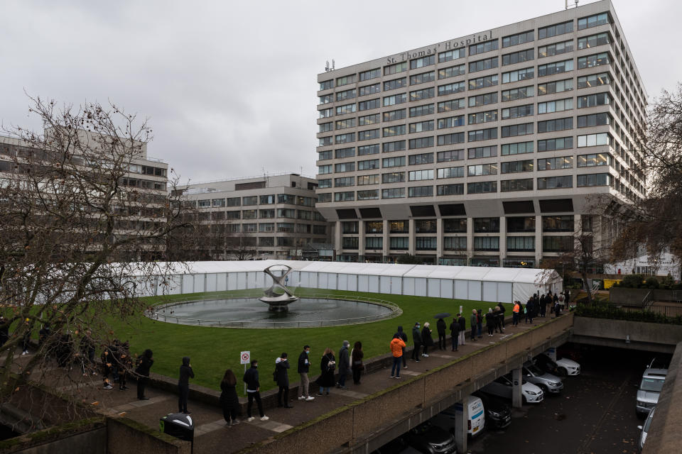 LONDON, UNITED KINGDOM - DECEMBER 13, 2021: People queue outside a Covid-19 vaccination centre set up at St Thomas' Hospital as the rollout of booster vaccines is extended to all adults in England this week to help tackle the rise in Omicron coronavirus cases on December 13, 2021 in London, England. Yesterday, the British Prime Minister Boris Johnson announced the government's plan to deliver booster shots to all adults by the New Year, amounting to an average of 1 million doses per day, as the UK Covid Alert has been increased to Level 4 due to the rapid increase in Omicron cases. (Photo credit should read Wiktor Szymanowicz/Future Publishing via Getty Images)