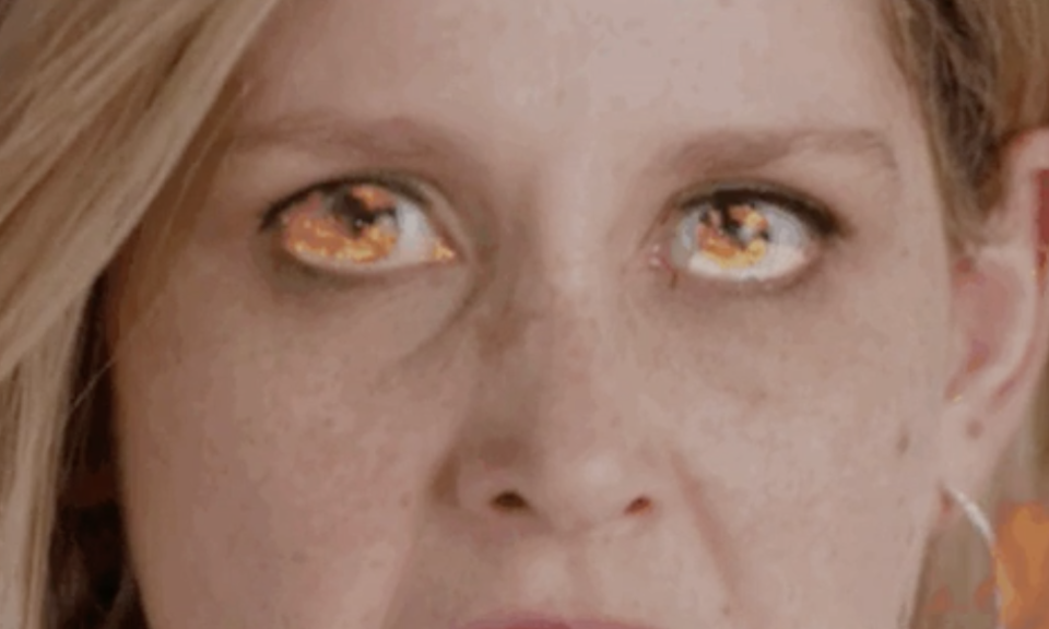 Close-up of a person's face with eyes edited to look like flames, possibly representing intense passion or love