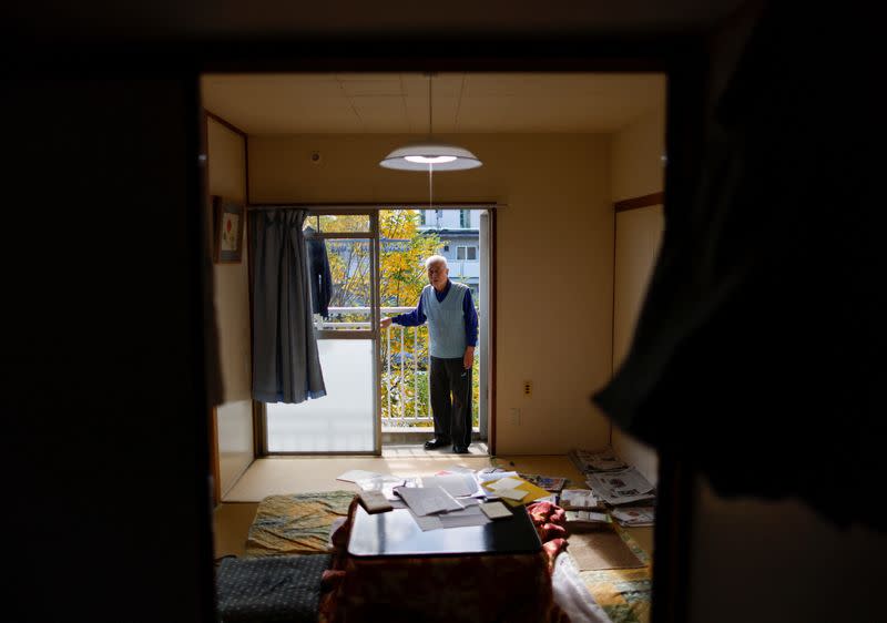 Pensioner Yoshio Koitabashi stands on the balcony of his apartment in a public housing complex in Tokyo