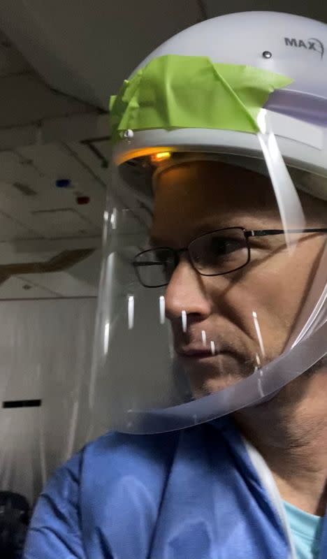 Dr. Michael Callahan wears protective gear in mid-flight to guard against infection