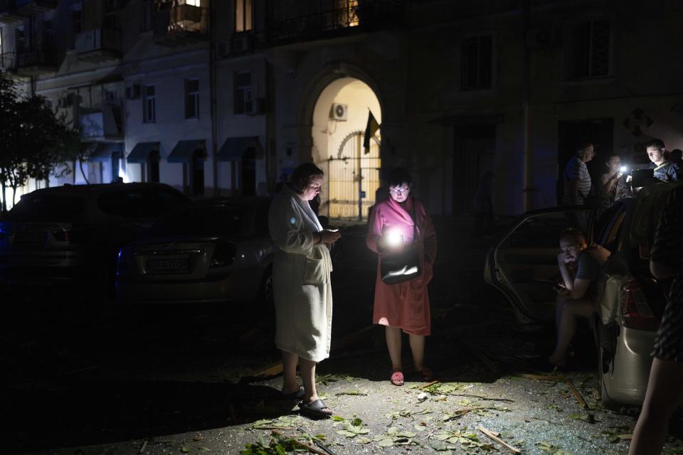 Residents stand outsid their apartment building in Odesa, Ukraine, Sunday, July 23, 2023, following Russian missile attacks. (AP Photo/Jae C. Hong)
