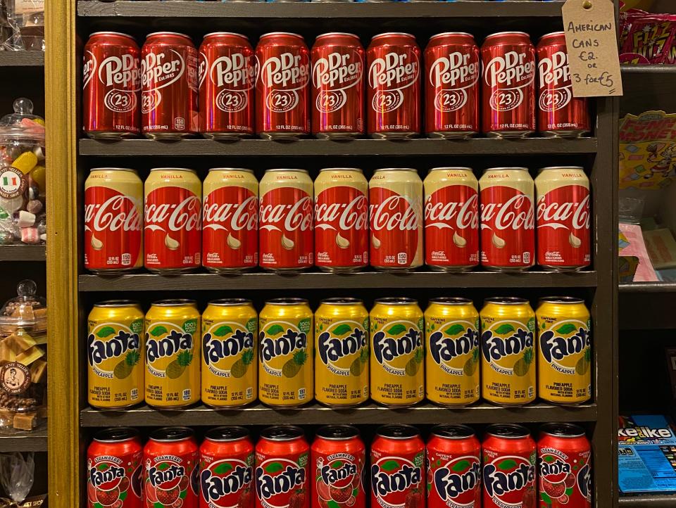 cans of american soda brands lining a shelf of an irish grocery store