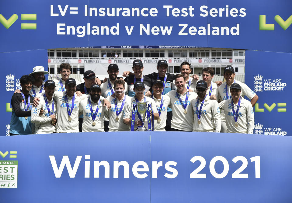 New Zealand players celebrate with the winners trophy after their win in the second cricket test match between England and New Zealand at Edgbaston in Birmingham, England, Sunday, June 13, 2021. New Zealand won the series 1-0. (AP Photo/Rui Vieira)