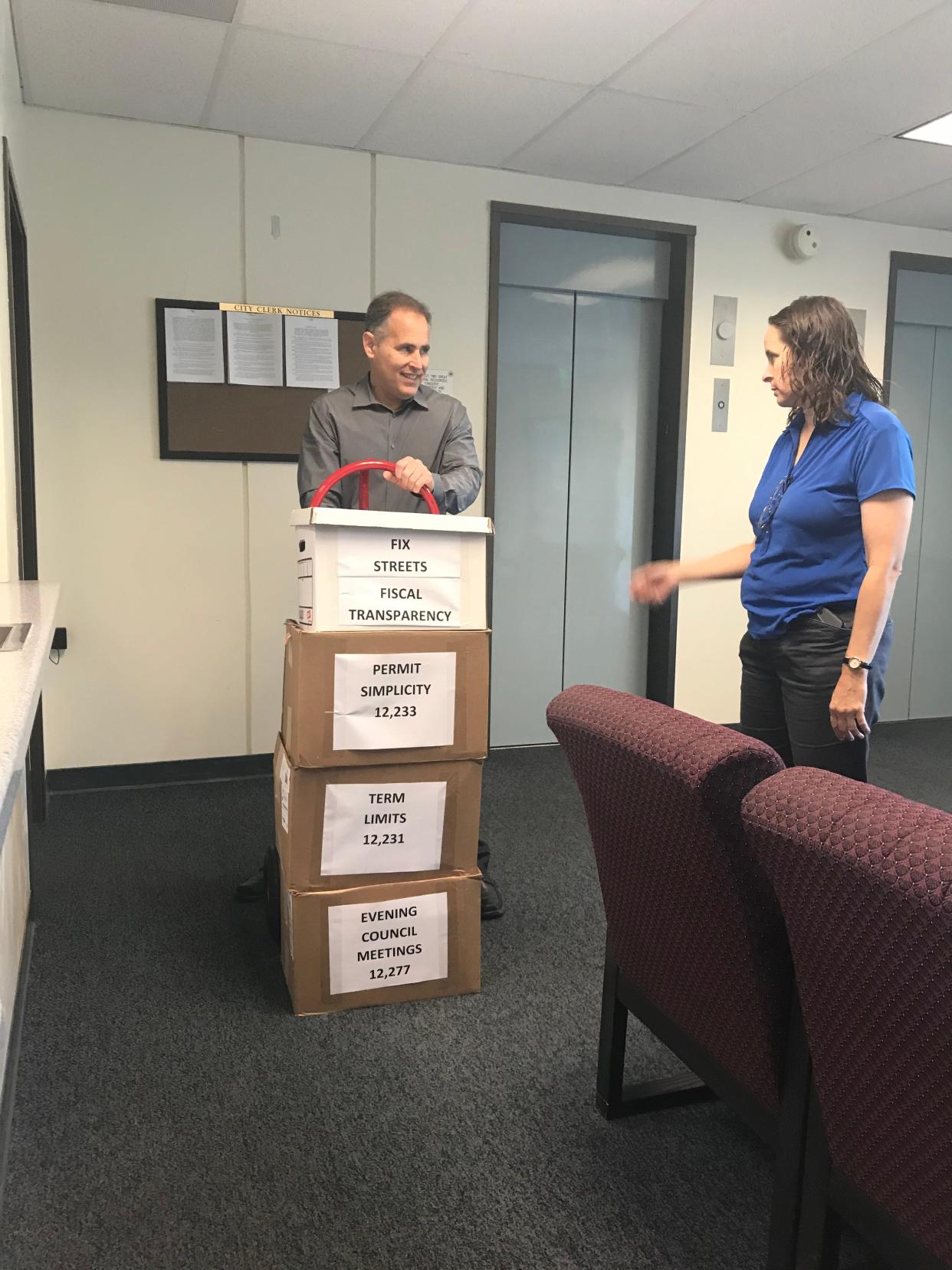 Aaron Starr, left, and Alicia Percell in 2019 submitted boxes of signed petitions for their ballot initiatives on Oxnard government. On Tuesday, the City Council placed a measure about term limits on the November ballot to comply with a court order.