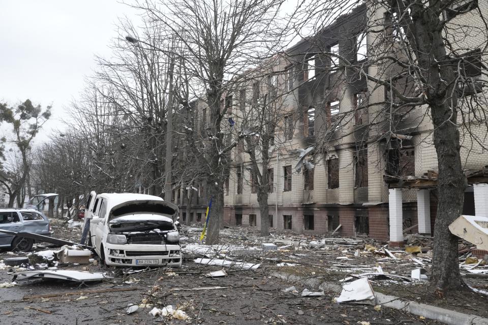 Damaged cars and a destroyed accommodation building are seen near a checkpoint in Brovary, outside Kyiv, Ukraine, Tuesday, March 1, 2022. Russian shelling pounded civilian targets in Ukraine's second-largest city Tuesday and a 40-mile convoy of tanks and other vehicles threatened the capital — tactics Ukraine's embattled president said were designed to force him into concessions in Europe's largest ground war in generations. (AP Photo/Efrem Lukatsky)