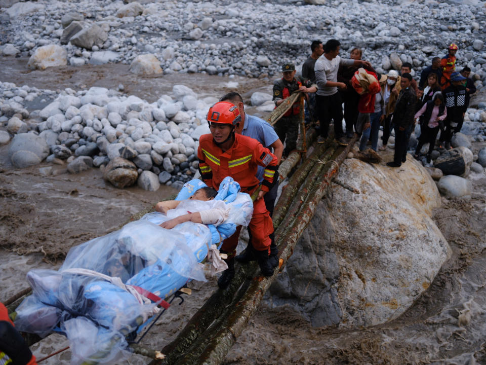 Rescue workers carry an injured victim on a stretcher following a 6.8-magnitude earthquake in Qinggangping village, Luding county, Ganzi Tibetan Autonomous Prefecture, Sichuan province, China September 5, 2022. China Daily via REUTERS  ATTENTION EDITORS - THIS IMAGE WAS PROVIDED BY A THIRD PARTY. CHINA OUT.