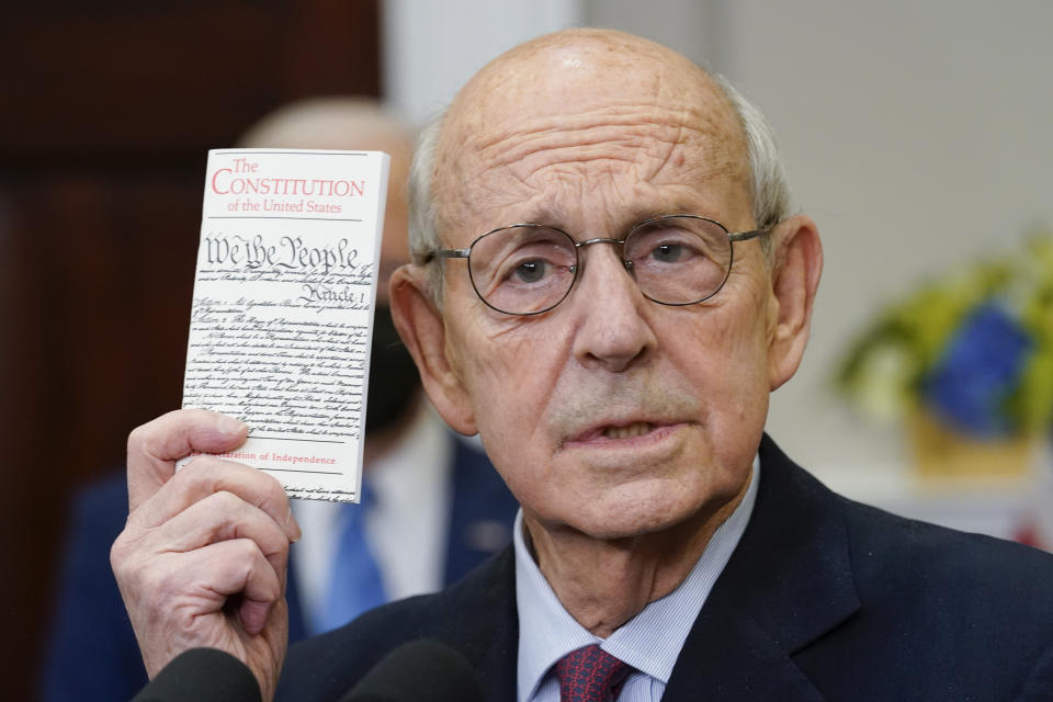 FILE - Supreme Court Associate Justice Stephen Breyer holds up a copy of the United States Constitution as he announces his retirement in the Roosevelt Room of the White House in Washington, Jan. 27, 2022. The fertile mind of Breyer has conjured a stream of hypothetical questions through the years that have, in the words of a colleague, "befuddled" lawyers and justices alike.(AP Photo/Andrew Harnik, File)