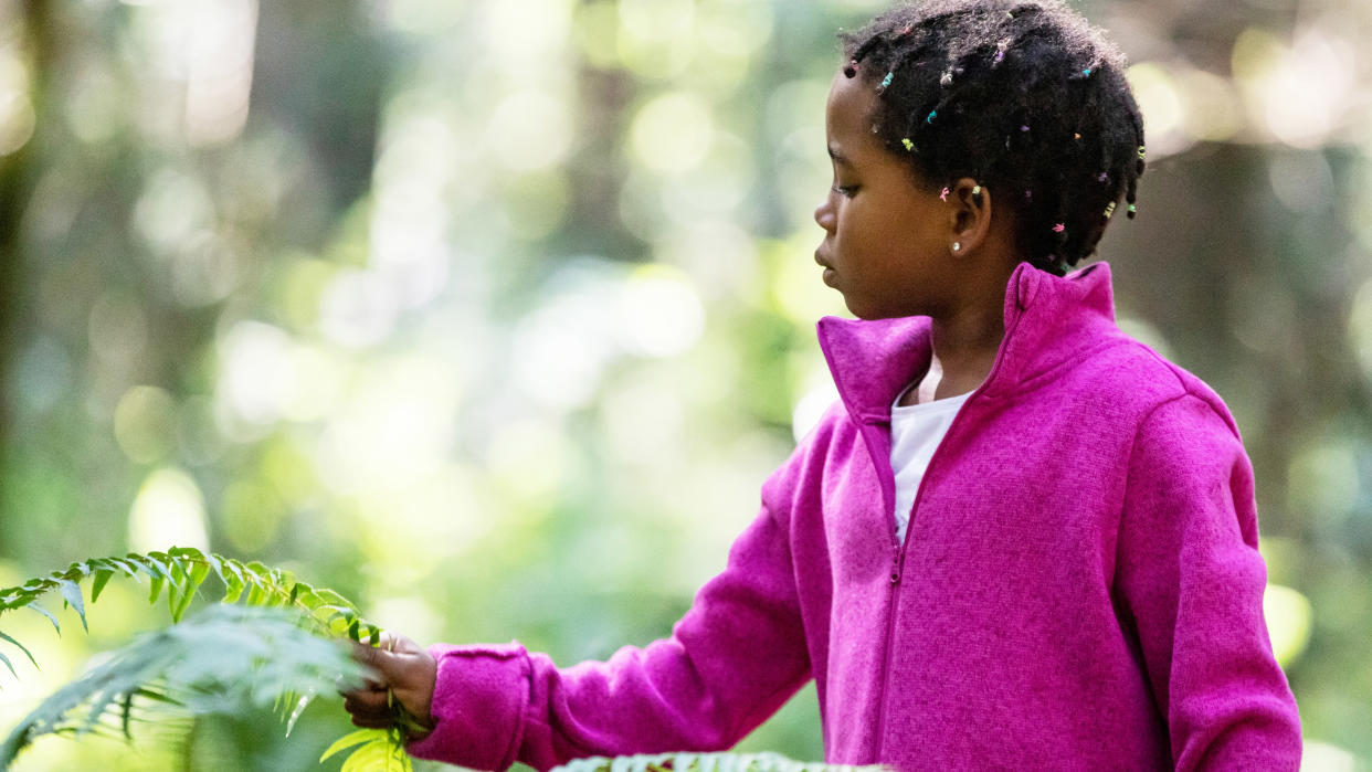  Child in fleece exploring nature. 