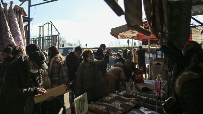 Turis Bulgaria berbelanja di bazaar di Edirne, dekat perbatasan Bulgaria, di Turki, pada 24 Desember 2021. Pemberhentian pertama mereka adalah penukaran mata uang, kemudian pasar dan toko kelontong untuk membeli mulai dari bahan makanan hingga perlengkapan kebersihan. (AP Photo/Emrah Gurel)