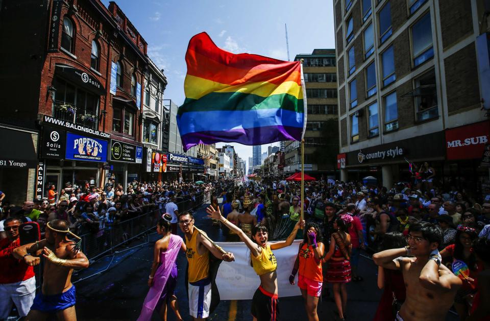 Revellers march along a street as they participate in the" WorldPride" gay pride Parade in Toronto