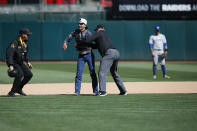 Umpire Jeff Nelson tackles a fan that ran onto the field during the game between the Oakland Athletics and the Toronto Blue Jays at the Oakland-Alameda County Coliseum on April 20, 2019 in Oakland, California. The Blue Jays defeated the Athletics 10-1. (Photo by Michael Zagaris/Oakland Athletics/Getty Images)