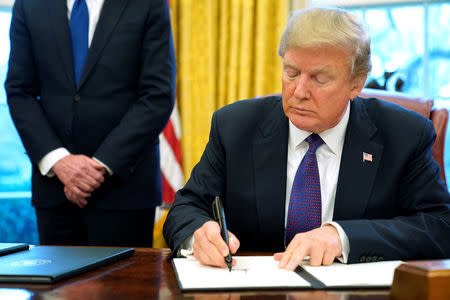 U.S. President Donald Trump signs a directive to impose tariffs on imported washing machines in the Oval Office at the White House in Washington, U.S. January 23, 2018. REUTERS/Jonathan Ernst