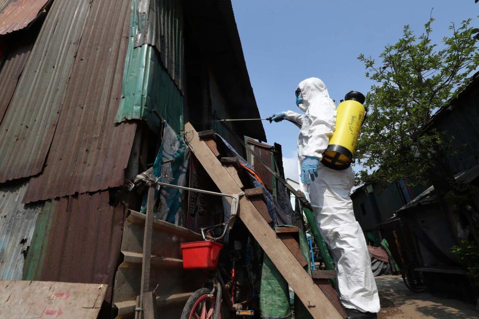 An employee of the non-profit Cambodian Children's Fund sprays disinfectant i (AP)