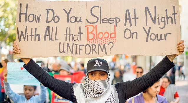 A woman, who declined to give her name, joins several hundred others in Oakland, California during a protest against the shooting of Michael Brown, an unarmed black 18-year old by a white police officer in Ferguson, Missouri. Photo: AP