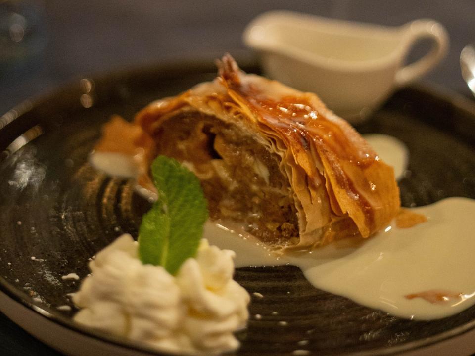 Apple strudel with iceream on a black plate