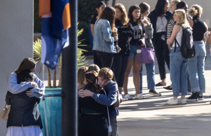 Malibu, CA - October 19: Pepperdine University students embrace as students, faculty and greater campus community members make a somber procession into the Firestone Field house for a vigil honoring four students who were killed in a horrific traffic accident on Pacific Coast Highway in on Thursday, Oct. 19, 2023 in Malibu, CA. (Brian van der Brug / Los Angeles Times)