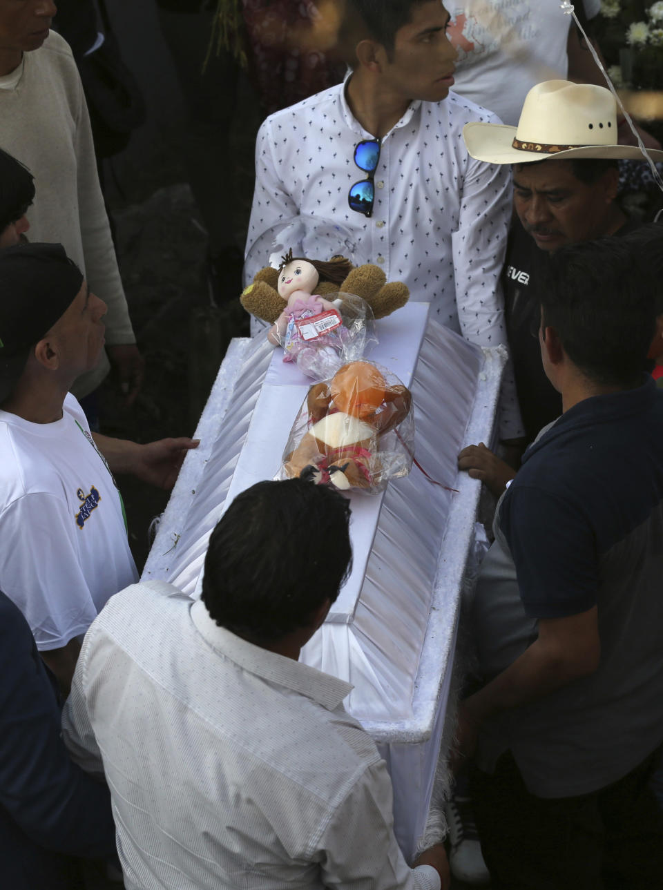 Family members bury 7-year-old murder victim Fatima in Mexico City, Tuesday, Feb. 18, 2020. Fatima's body was found wrapped in a bag and abandoned in a rural area on Saturday. Five people have been questioned in the case, and video footage of her abduction exists. (AP Photo/Marco Ugarte)