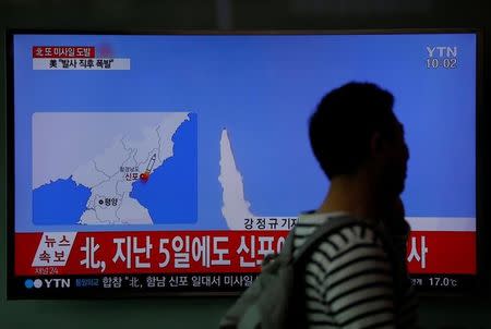 A passenger walks past a TV broadcasting a news report on North Korea's failed missile launch from its east coast, at a railway station in Seoul, South Korea, April 16, 2017. REUTERS/Kim Hong-Ji