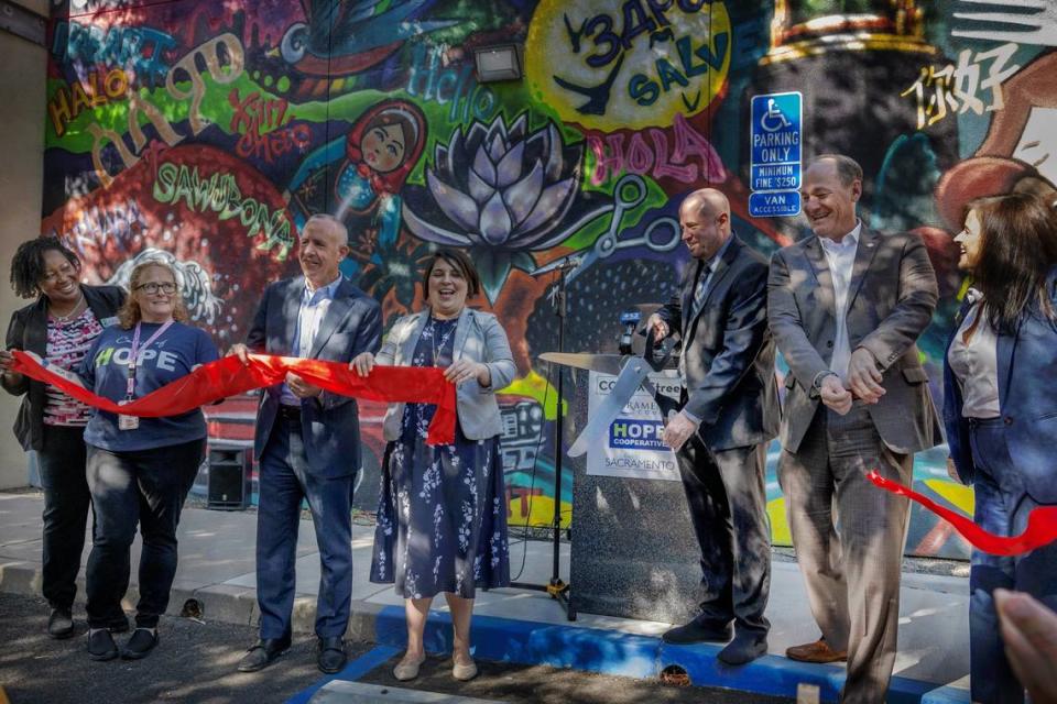 Dr. Ryan Quist, director, Sacramento County Behavioral Health, center, celebrates with other dignitaries including Sacramento Mayor Darrell Steinberg, Councilmember Katie Valenzuela, and Supervisor Rich Desmond, after cutting a ribbon during the grand opening of the Community Outreach Recovery Empowerment, or CORE, program site at 1400 X Street in Sacramento on Thursday.