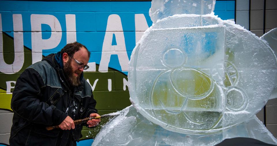 Sculptor Harvey Russell from St. Louis works on a piece outside of Upland Brewery during Freezefest on Friday, Jan. 20, 2023.