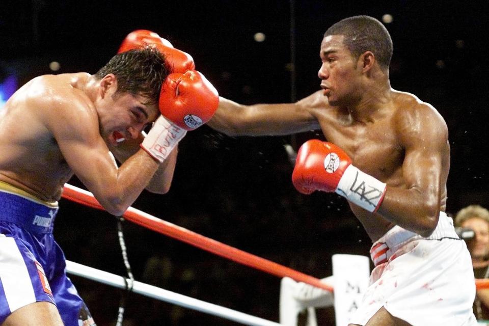 Felix Trinidad throwing a straight right to a defending Oscar De La Hoya