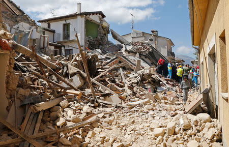 Un devastador terremoto sacudió la madrugada del miércoles una serie de localidades montañosas del centro de Italia y dejó al menos 120 personas muertas, residentes atrapados bajo los escombros y un número indeterminado de desaparecidos. En la imagen, varias personas y equipos de rescate tras el terremoto en Amatrice, Italia, el 24 de agosto de 2016. REUTERS/Ciro De Luca