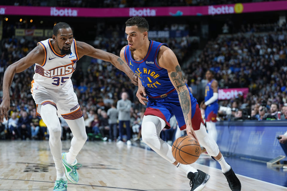 Denver Nuggets forward Michael Porter Jr., right, drives past Phoenix Suns forward Kevin Durant during the second half of an NBA basketball game Tuesday, March 5, 2024, in Denver. (AP Photo/David Zalubowski)