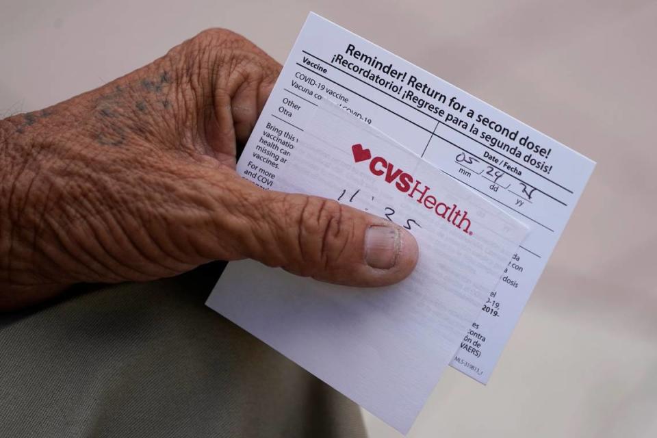 A man holds his vaccination reminder card after having received his first shot at a pop-up vaccination site next to Maximo Gomez Park, also known as Domino Park, Monday, May 3, 2021, in the Little Havana neighborhood of Miami.