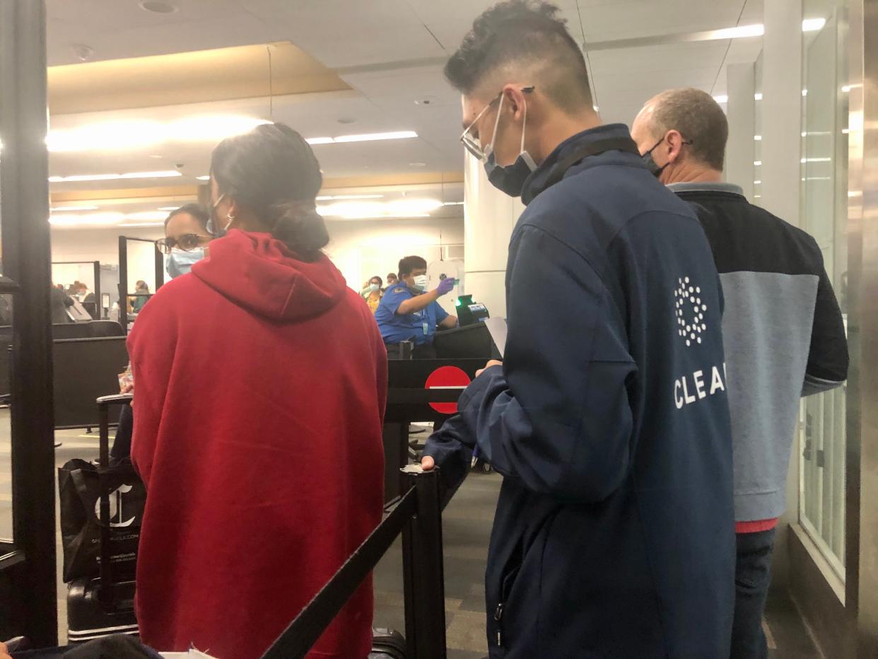 A CLEAR attendant bringing travelers to their security line at the airport.