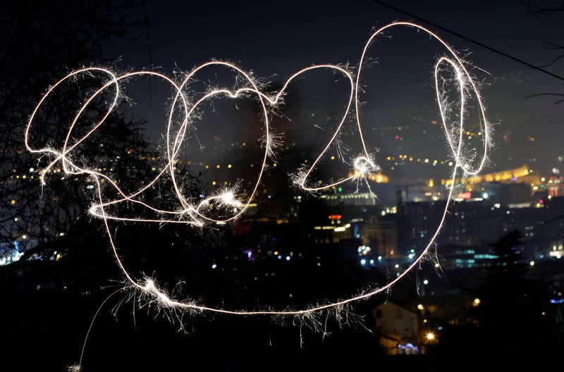 A girl with sparkle writes 2020 during New Year celebration in Skopje