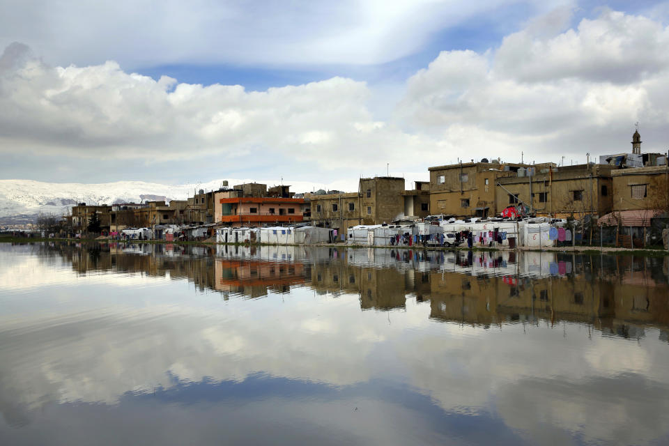Syrian refugee's tents are reflected in a pool of rain water at a refugee camp in the town of Bar Elias, in the Bekaa Valley, Lebanon, Thursday, Jan. 10, 2019. A storm that battered Lebanon for five days displaced many Syrian refugees after their tents got flooded with water or destroyed by snow. (AP Photo/Bilal Hussein)