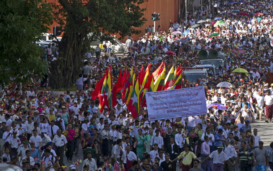 Demonstrators march through the streets during a pro-military rally Sunday, Oct. 14, 2018, in front of city hall in Yangon, Myanmar. Several thousand pro-military and nationalist demonstrators marched through Yangon on Sunday voicing their support for Myanmar's armed forces and government while condemning foreign involvement in the country's affairs. (AP Photo/Thein Zaw)