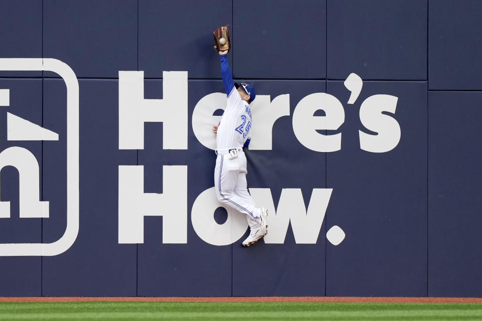 Toronto Blue Jays left fielder Daulton Varsho (25) makes a jumping catch on a hit by Kansas City Royals' Salvador Perez during the first inning of a baseball game in Toronto, Saturday, Sept. 9, 2023. (Nathan Denette/The Canadian Press via AP)