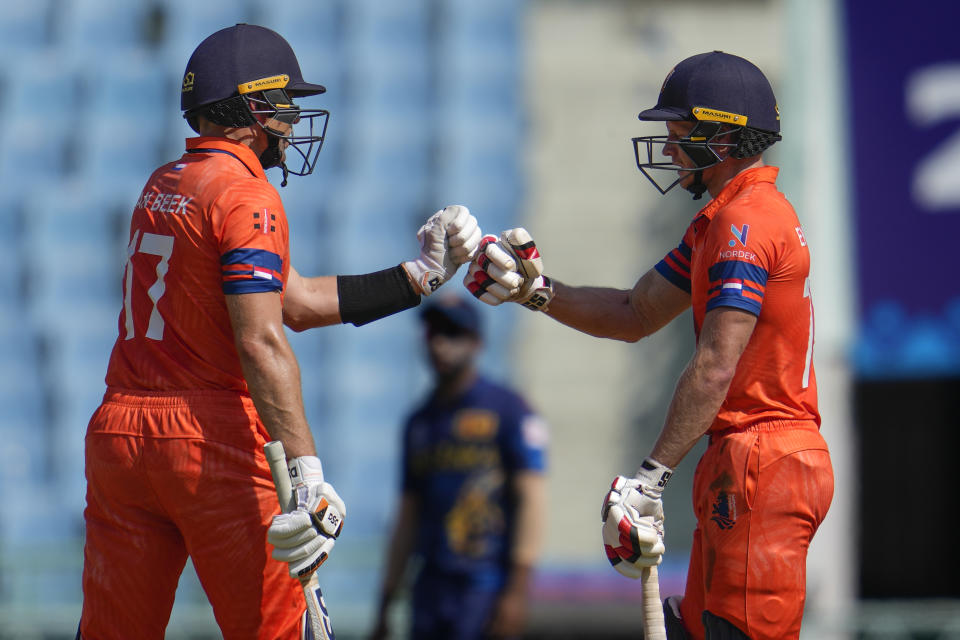 Netherlands' Sybrand Engelbrecht, right, and his batting partner Logan Van Beek bump fists as they bat during the ICC Men's Cricket World Cup match between Sri Lanka and Netherlands in Lucknow, India, Saturday, Oct. 21, 2023. (AP Photo/Altaf Qadri)