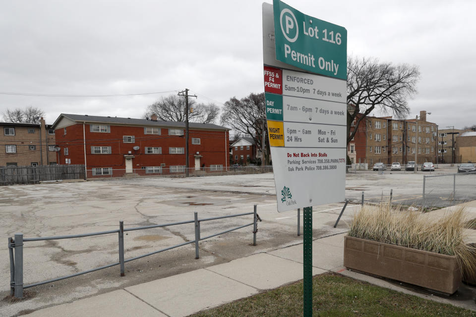 A municipal parking lot in the Village of Oak Park, Ill., sits empty Friday, March 20, 2020. There are at least three confirmed cases of COVID-19 in Oak Park, just nine miles from downtown Chicago, where the mayor has ordered residents to shelter in place. With so few tests available, surely there are others, says Tom Powers, spokesman for the village of about 52,000 in a metropolitan area with millions. (AP Photo/Charles Rex Arbogast)
