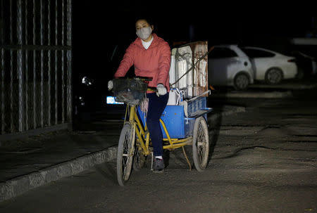 A migrant worker rides a tricycle filled with luggage as she was forced to move out of her apartment before midnight at a village outside the sixth ring road in Tongzhou district of Beijing, China November 23, 2017. Picture taken November 23, 2017. REUTERS/Jason Lee