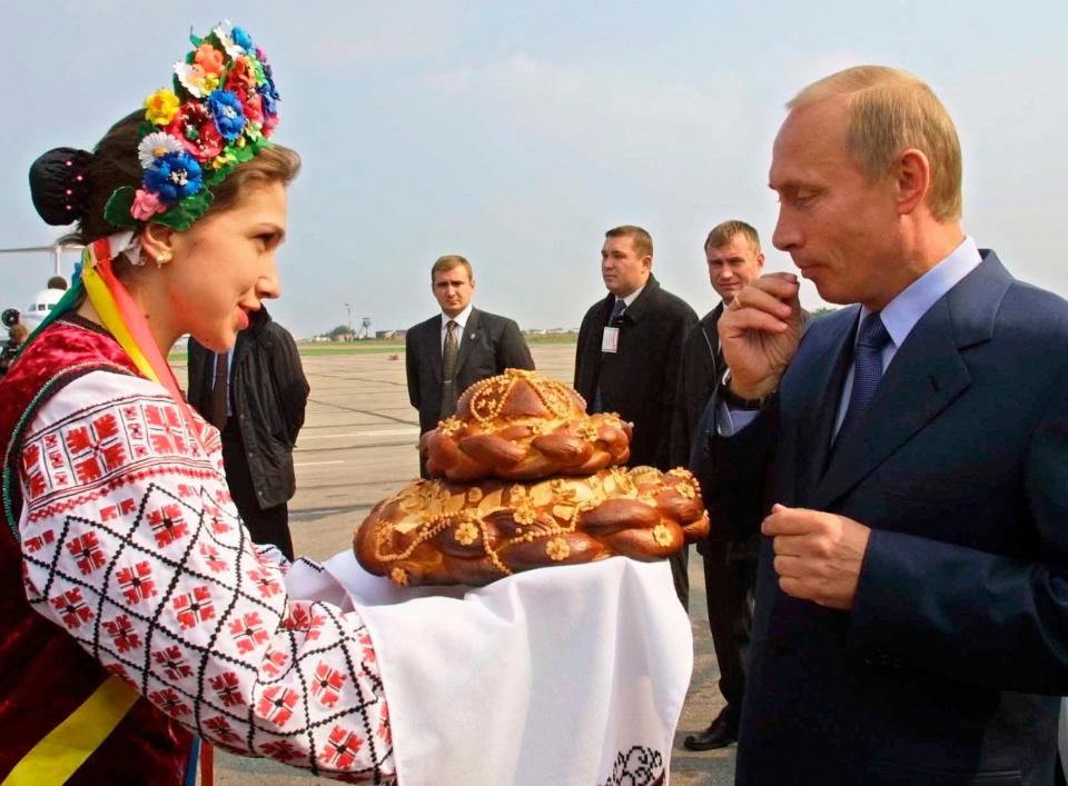 A woman in Ukrainian national dress welcomes Russian President Vladimir Putin with bread and salt in Zaporizhye airport, some 568 kilometers (352 miles) west of Ukraine's capital Kiev, on Oct. 6, 2002. Russia's present demands are based on Putin's purported long sense of grievance and his rejection of Ukraine and Belarus as truly separate, sovereign countries but rather as part of a Russian linguistic and Orthodox motherland.