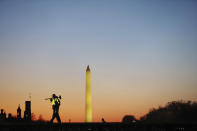 A construction worker carries a hammer on his shoulder on Wednesday, Jan. 13, 2021 at the National Mall in Washington, as a stage is prepared for the 2021 Democrat Joe Biden's presidential inauguration. (AP Photo/Shafkat Anowar)