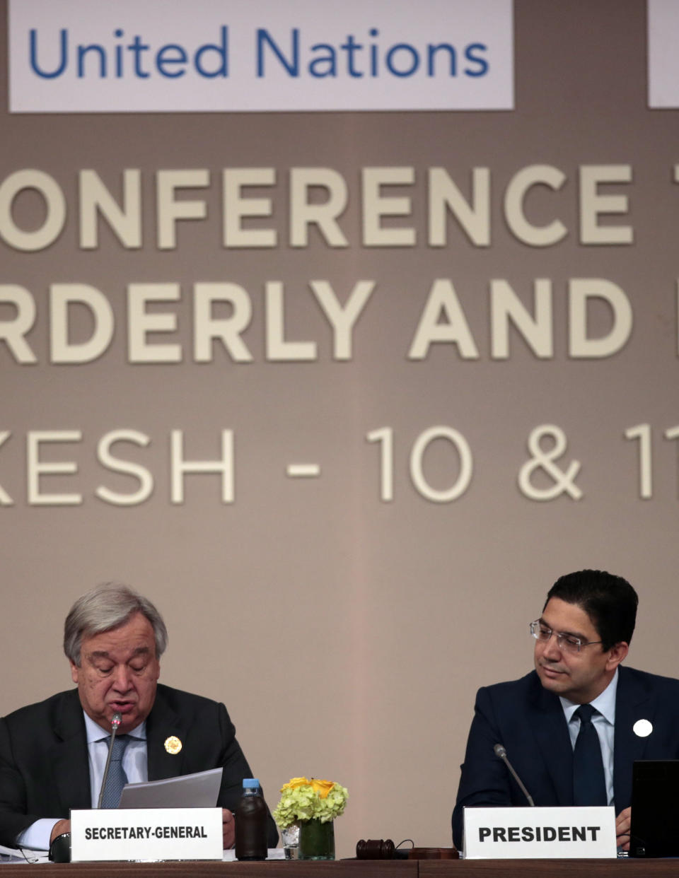 U.N. Secretary-General Antonio Guterres reads his speech while Moroccan Minister of Foreign Affairs and International Cooperation, Nasser Bourita, right, looks on, during the opening session of a UN Migration Conference in Marrakech, Morocco, Monday, Dec.10, 2018. Top U.N. officials and government leaders from about 150 countries are uniting around an agreement on migration, while finding themselves on the defensive about the non-binding deal amid criticism and a walkout from the United States and some other countries. (AP Photo/Mosa'ab Elshamy)