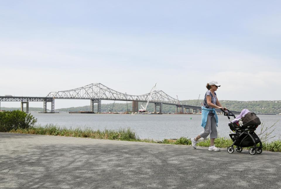 A woman takes a stroll with her child along the Westchester Riverwalk just north of the Tappan Zee Bridge, Tuesday, May 13, 2014, in Tarrytown, N.Y. On Wednesday, President Barack Obama plans to speak by the bridge just north of New York City to press his case that a key federal government fund used to pay for the nation's roads, bridges and ports is running dry and that the economy would be damaged if it is not replenished. (AP Photo/Julie Jacobson)