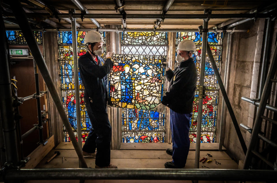 <p>Conservator Matthew Nickels (left) and Master Glazier Tony Cattle (right) from York Glaziers Trust removed a stained glass window panel at the start of a new five year, �5m project to conserve York Minster's South East Transept and its medieval St Cuthbert Window. Picture date: Tuesday May 25, 2021. Work is being undertaken by York Glaziers Trust to remove stained glass panels from the window, which is nearly 600-years-old and one of the largest surviving narrative windows in the world. The project involves major conservation and restoration works to both the stained glass and stone elements of the window and the South East Transept in which the window sits.</p>
