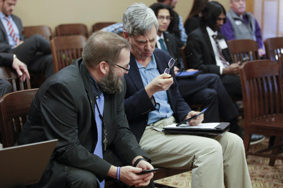 Bryan Caskey, left, state elections director in the Kansas secretary of state's office, and Clay Barker, right, the office's general counsel, confer during a Kansas Senate committee discussion of a bill that would eliminate ballot drop boxes in locations outside county election offices, Tuesday, Feb. 21, 2023, at the Statehouse in Topeka, Kan. Secretary of State Scott Schwab, a two-term Republican, is a vocal supporter of drop boxes and opposes the bill. (AP Photo/John Hanna)