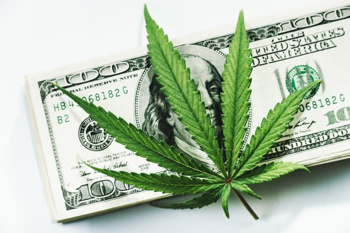 Marijuana leaf on top of $100 bills