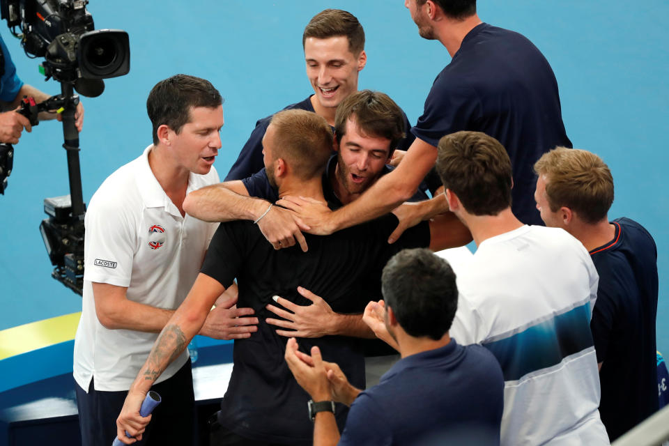 Britain's Dan Evans celebrates with captain Tim Henman and his team after winning his Quarter Final singles match against Australia's Alex de Minaur.